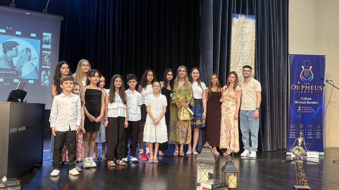 Group on stage at an award ceremony next to a banner reading The Orpheus Arts, Culture Without Borders