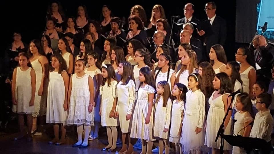 Choir members dressed in white performing together