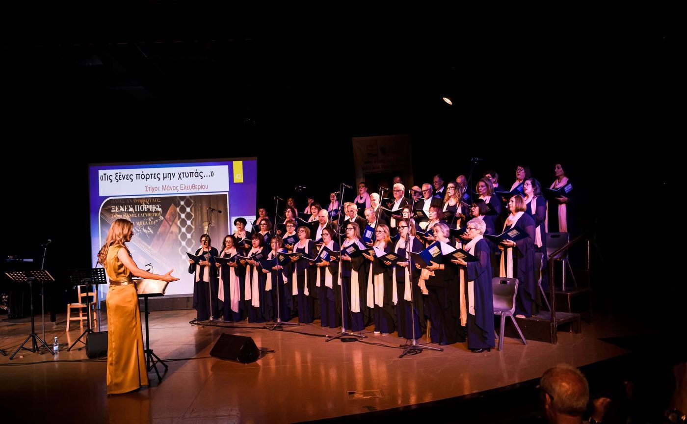A soloist in a gold dress conducting a robed choir on stage